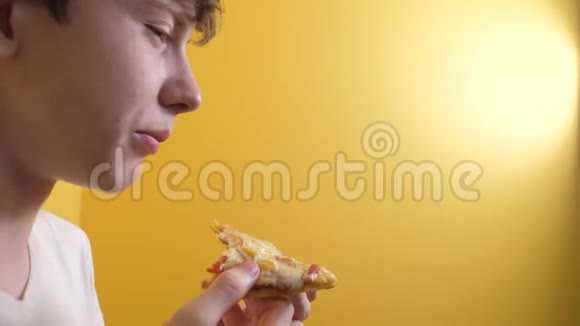披萨快乐的青少年男孩吃一片比萨饼的生活方式概念小男孩饿了吃一片披萨慢动作视频的预览图