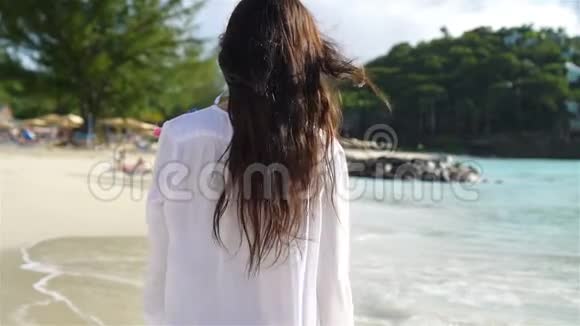 在热带海滨玩得很开心的年轻美女快乐的女孩在白沙热带海滩散步视频的预览图