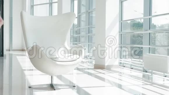 漂亮的女商人坐在玻璃办公室的白色椅子上检查文件视频的预览图
