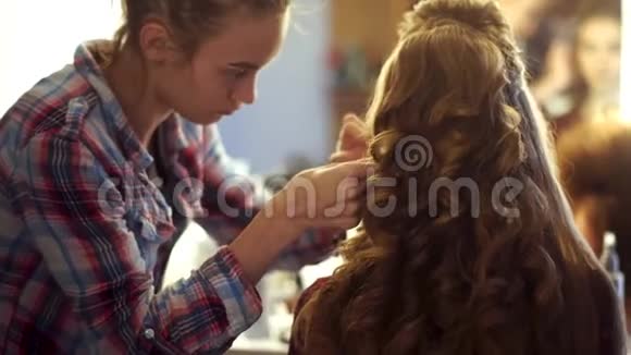 金发造型师女给年轻女子做发型视频的预览图