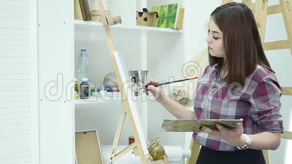 艺术家用调色板在手中画一幅油画视频的预览图