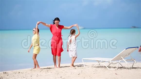可爱的小女孩和年轻的妈妈在白沙滩玩视频的预览图