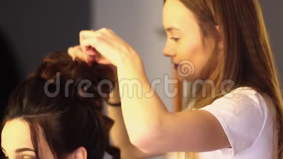年轻的金发造型师女给女人做发型视频的预览图