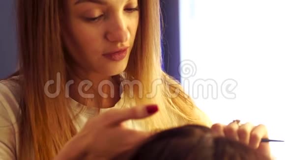 年轻的造型师女给女士做发型视频的预览图