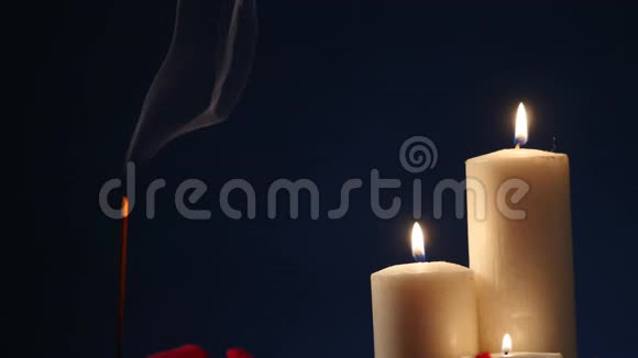 在黑暗的背景上燃烧着香枝和蜡烛在熏香和烛光中燃烧着视频的预览图