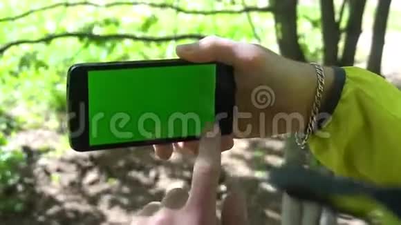 特写男性手触摸智能手机绿色屏幕Chroma键快关门跟踪运动视频的预览图