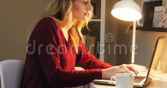 坐在桌子上的女人用笔记本电脑视频的预览图