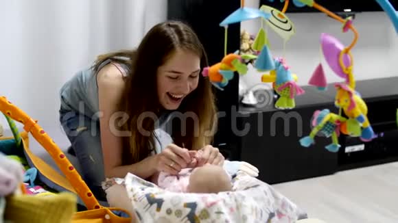 小刚出生的女孩躺在婴儿床上玩具视频的预览图