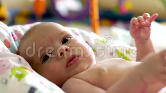 一个快乐的小女孩躺在婴儿床上微笑着视频的预览图