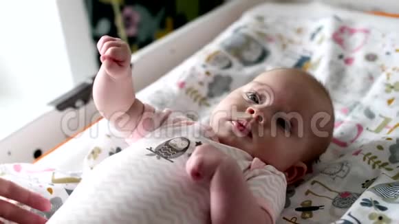 小刚出生的女孩躺在婴儿床上玩具视频的预览图