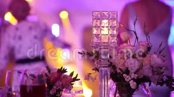 餐桌上的装饰蜡烛桌子上的眼镜和圣诞蜡烛背景中的派对餐厅视频的预览图