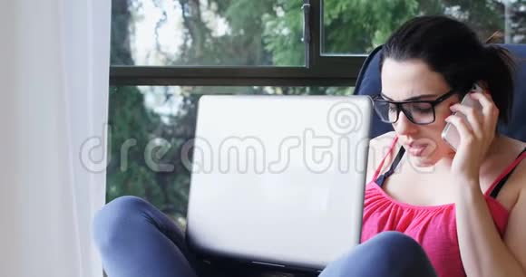 美女一边用笔记本电脑一边讲手机4k视频的预览图
