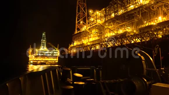 晚上FPSO油轮靠近石油平台钻机海洋石油和天然气工业视频的预览图