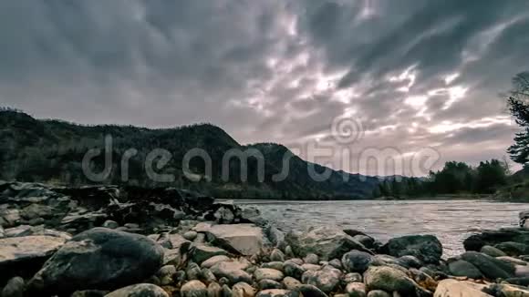 山林附近一条河流的时间流逝巨大的岩石和快速的云层移动水平滑块运动视频的预览图