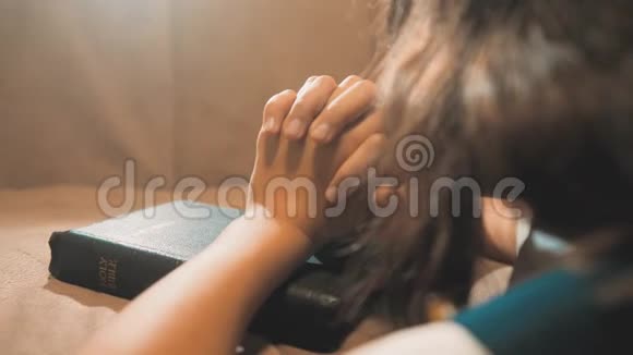 小女孩在夜里祈祷小女孩用手祈祷小女孩的生活方式圣圣经在她的圣经中祈祷视频的预览图