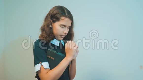 小女孩用手中的圣经祈祷天主教神圣的圣经儿童与宗教视频的预览图