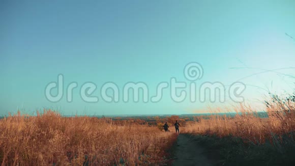 两个男人的生活方式旅行者带着背包徒步旅行沿着爬山的小路走着慢动作视频的预览图