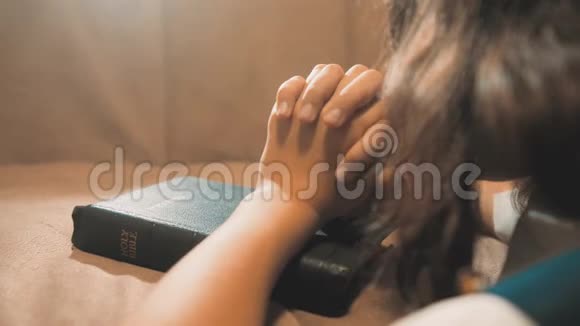 小女孩在夜里祈祷小女孩用手祈祷小生活方式女孩圣经祈祷圣经在她的圣经视频的预览图