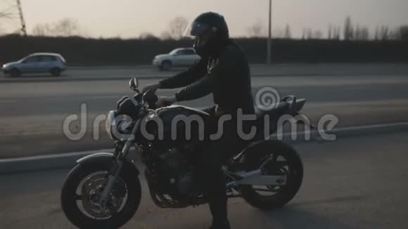 带着黑色头盔和运动摩托车的年轻有魅力男子摩托车手视频的预览图