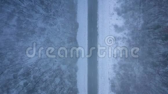 暴风雪中道路和冬季森林的鸟瞰图视频的预览图