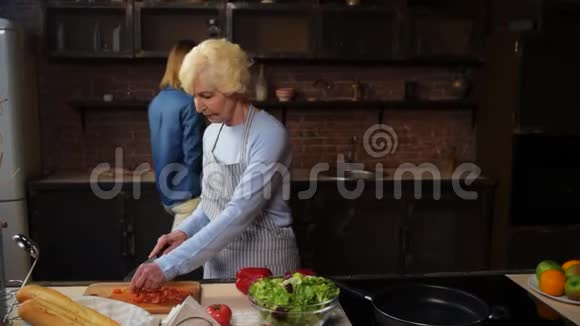 漂亮的老妇人在厨房做饭视频的预览图