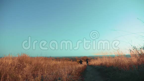 两个男子旅行者的生活方式徒步旅行与背包正走在小径上爬山慢动作视频的预览图
