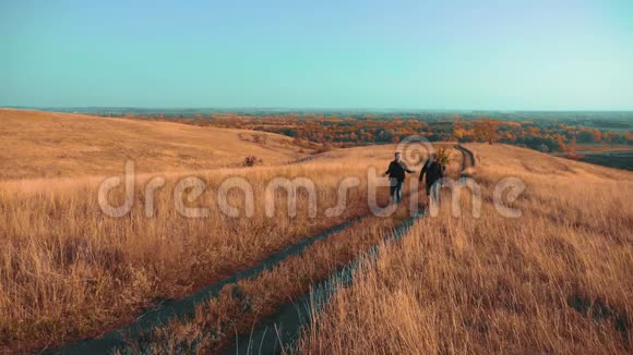 两个背着背包徒步旅行的人正沿着小路爬山慢生活方式运动视频的预览图