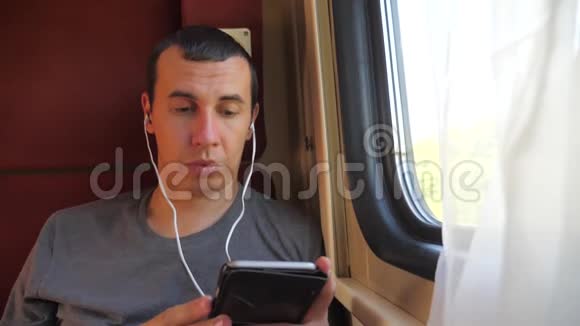 男子听着火车车厢车厢车厢车厢上的音乐旅行慢动作视频男人的生活方式视频的预览图