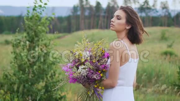 一位年轻女子站在绿茵场上手里拿着一束鲜花视频的预览图