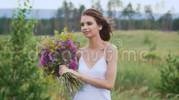 一位年轻女子站在绿茵场上手里拿着一束鲜花视频的预览图