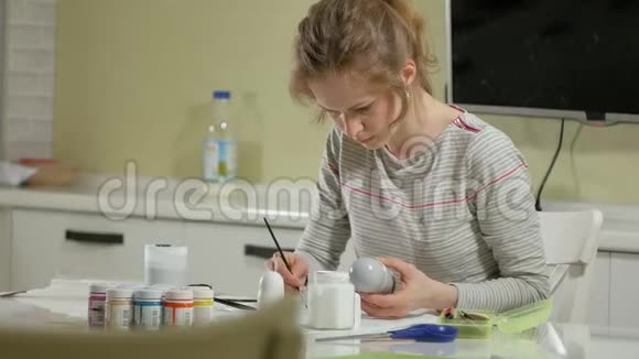 一个女人在家里的画室里画了一个木娃娃和彩色颜料视频的预览图
