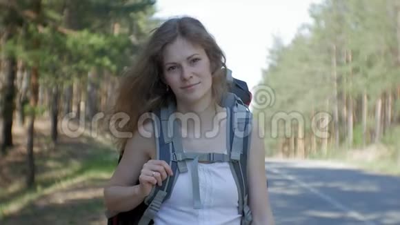 年轻漂亮的女人搭车站在路上背包放在桌上上面写着南方视频的预览图