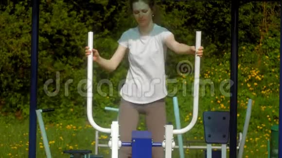 年轻的健身妇女在户外公园的健身房锻炼视频的预览图