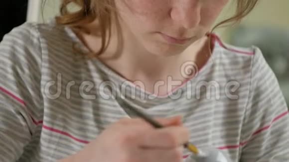 一个女人在家里的画室里画了一个木娃娃和彩色颜料视频的预览图