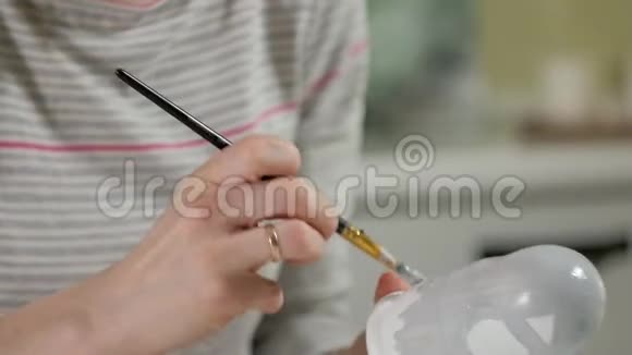 一个女人在她的家庭工作室里画了一个木娃娃上面画着彩色的颜料Matryoshka画特写视频的预览图