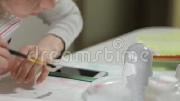 一个女人在她的家庭工作室里画了一个木娃娃上面画着彩色的颜料Matryoshka画特写视频的预览图