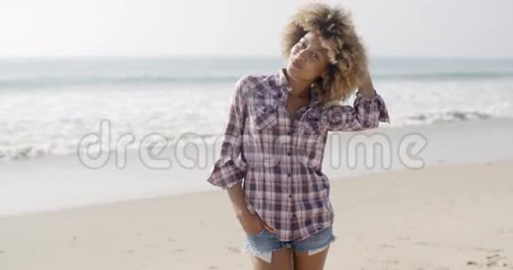 站在沙滩上的休闲年轻女子视频的预览图