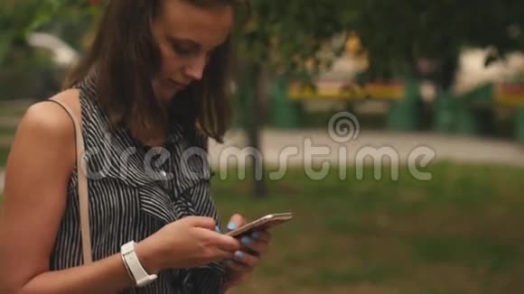 美丽的女人在公园里写着夏天散步的信息视频的预览图