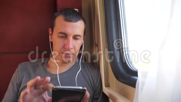 男子听音乐在火车上旅行火车车厢车厢旅行慢动作视频一个男人视频的预览图