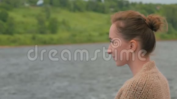 年轻女子站在游轮甲板上看着河流和风景视频的预览图