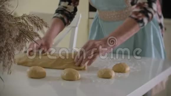 快乐的高级女人在家里厨房里擀比萨饼面团视频的预览图
