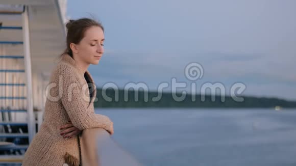 日落后游船甲板上欣赏风景的女人视频的预览图