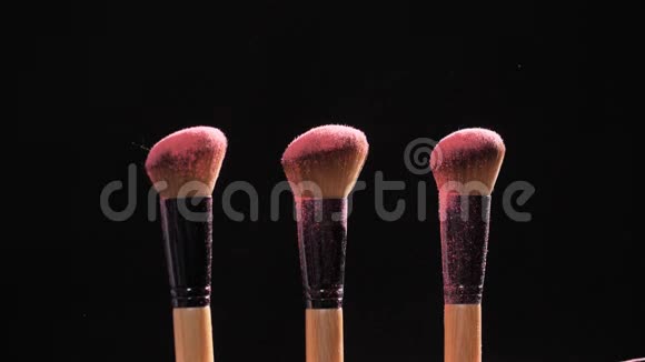 化妆和美容观念刷粉红色粉末爆炸黑色背景视频的预览图