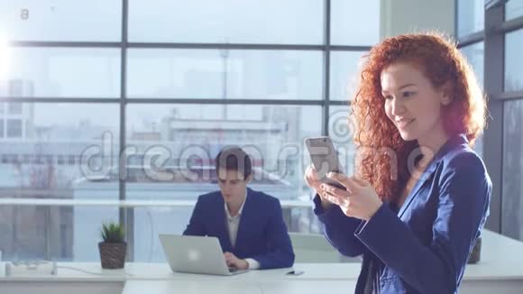 女商人在现代办公室使用智能手机的肖像视频的预览图