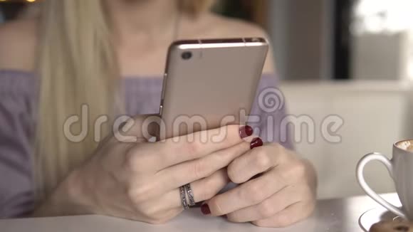 女性在喝咖啡时使用智能手机视频的预览图