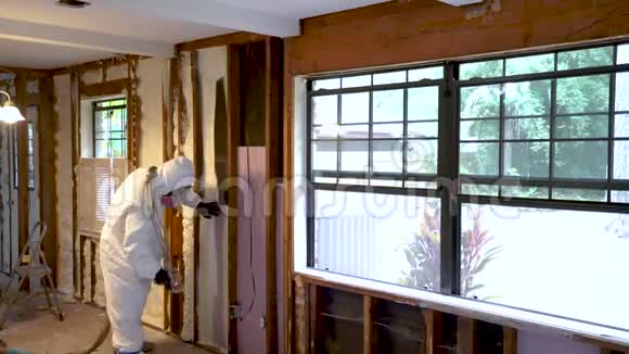 工人在家墙上喷涂封闭的电池喷涂泡沫绝缘材料视频的预览图