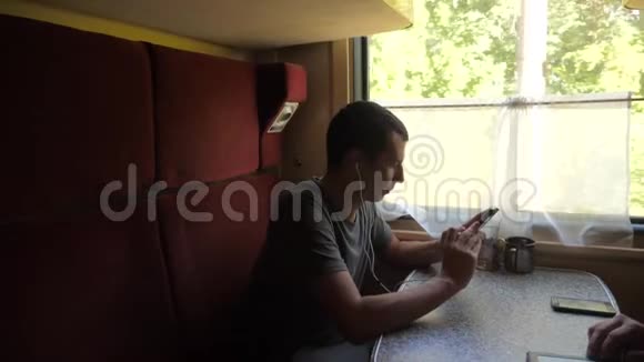 火车车厢上的人剪影听着耳机里的音乐在信使社里写着信息视频的预览图