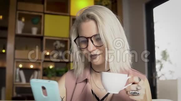 女性在喝咖啡时使用智能手机视频的预览图