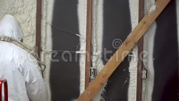 工人在家墙上喷涂封闭的电池喷涂泡沫绝缘材料视频的预览图