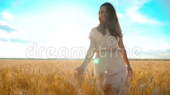 女孩正沿着麦田走大自然慢动作视频美丽的女孩穿着白色的裙子奔跑着大自然的自由视频的预览图